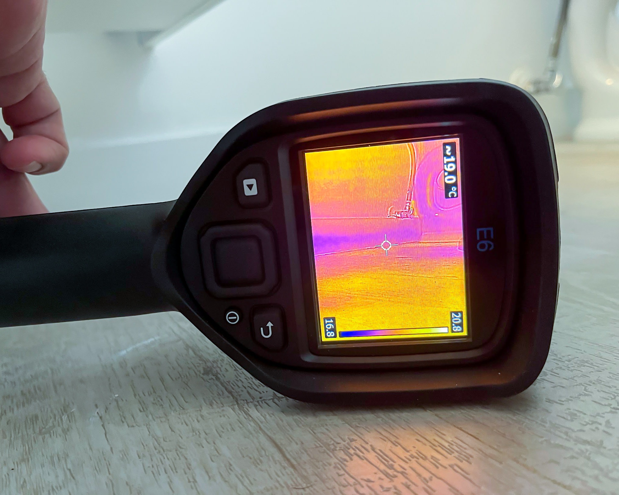 FLIR E6 thermal camera on bathroom floor showing moisture spread pattern