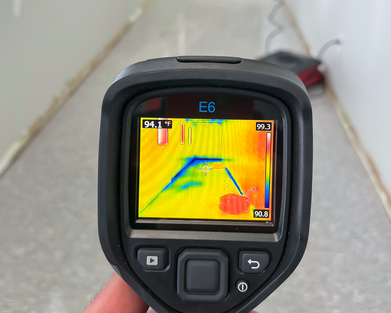 FLIR E6 thermal camera showing 94°F moisture reading during water damage inspection