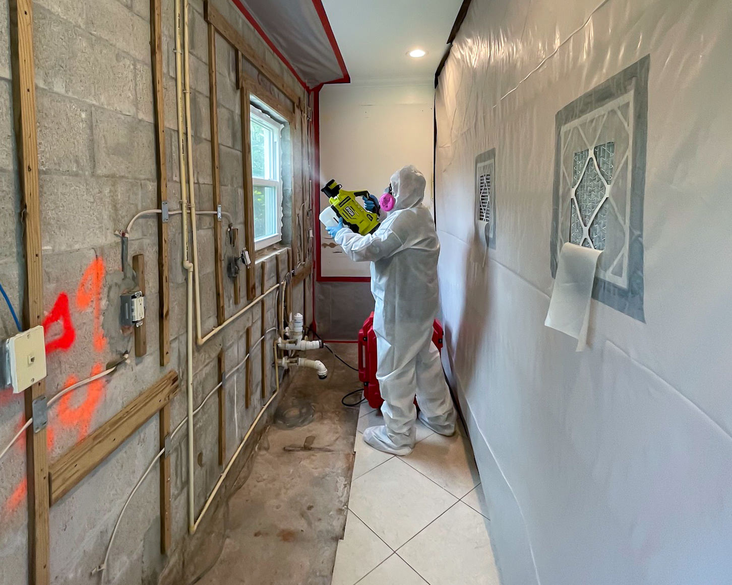 PPE specialist applying odor treatment inside containment zone