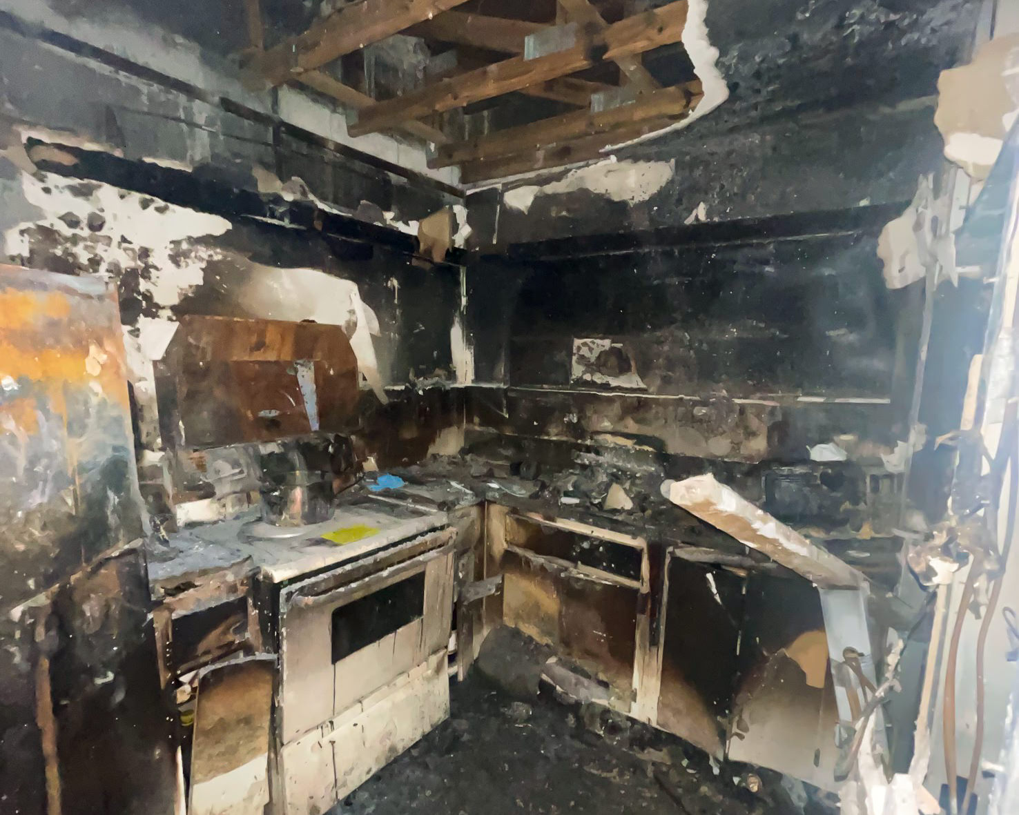 Fire-damaged kitchen — complete destruction from residential fire