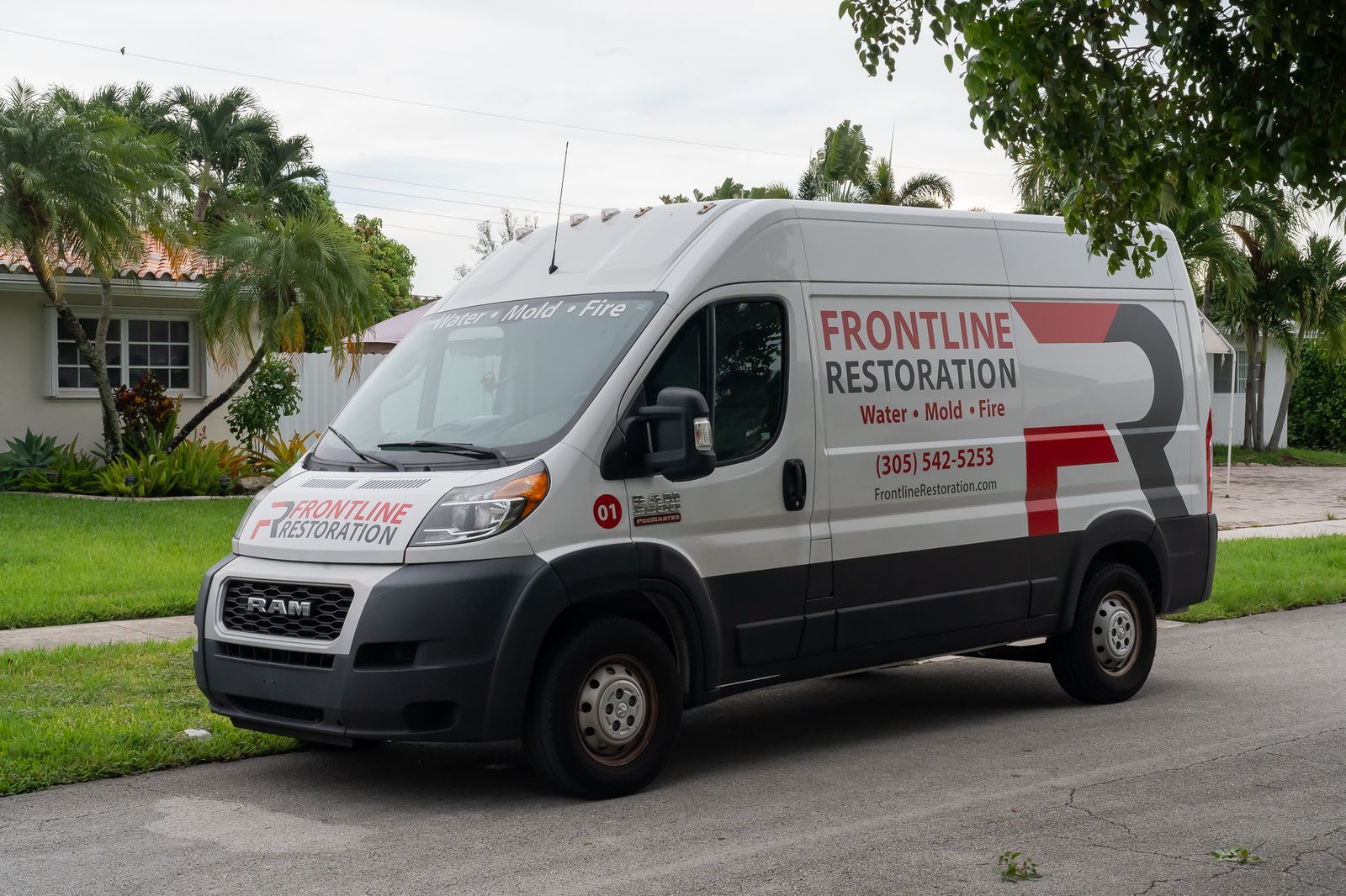 Frontline Restoration service van parked outside a Miami home